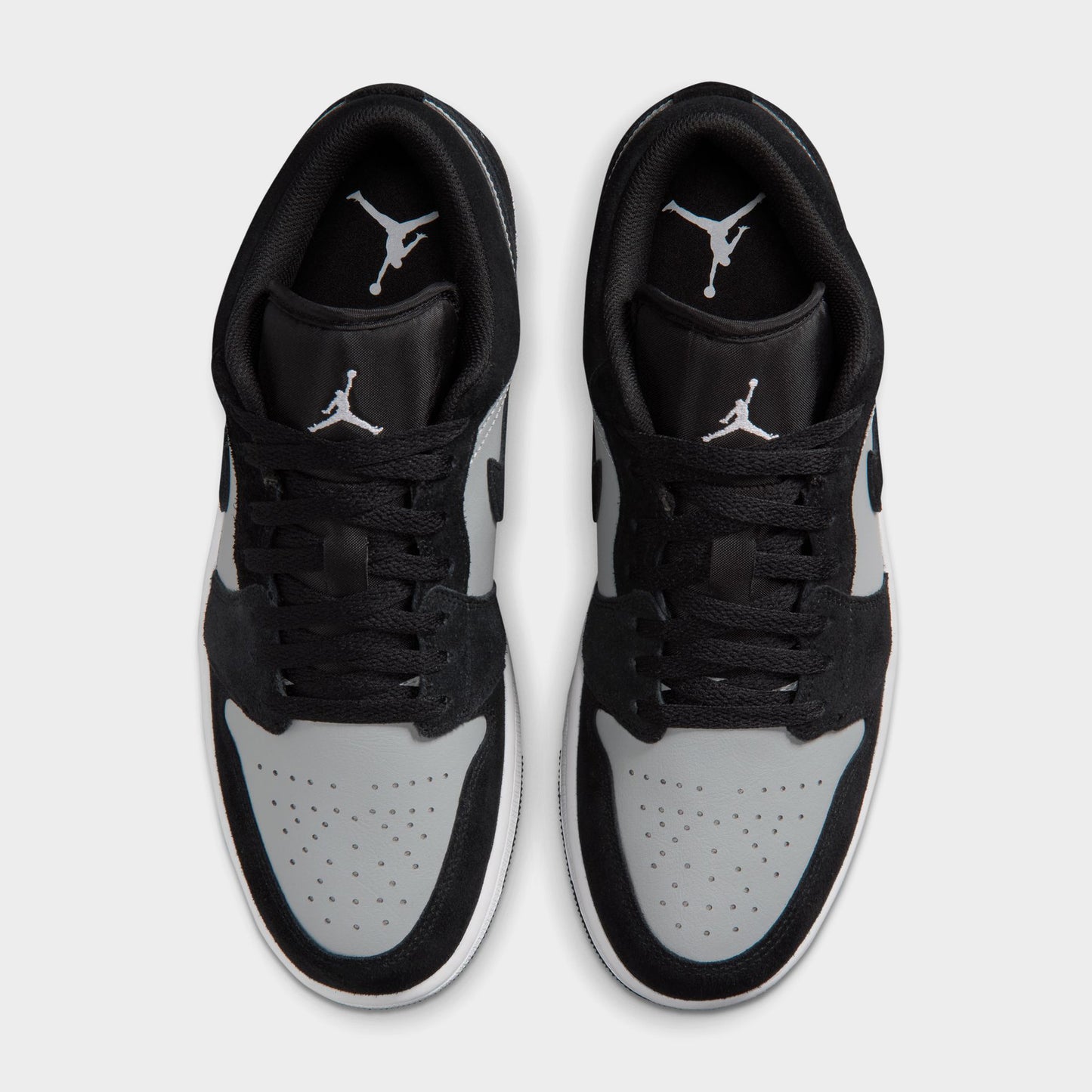 Jordan 1 Low. Top view of black, white and light smoke grey sneakers showing black laces, white toe boxes and padded collars.