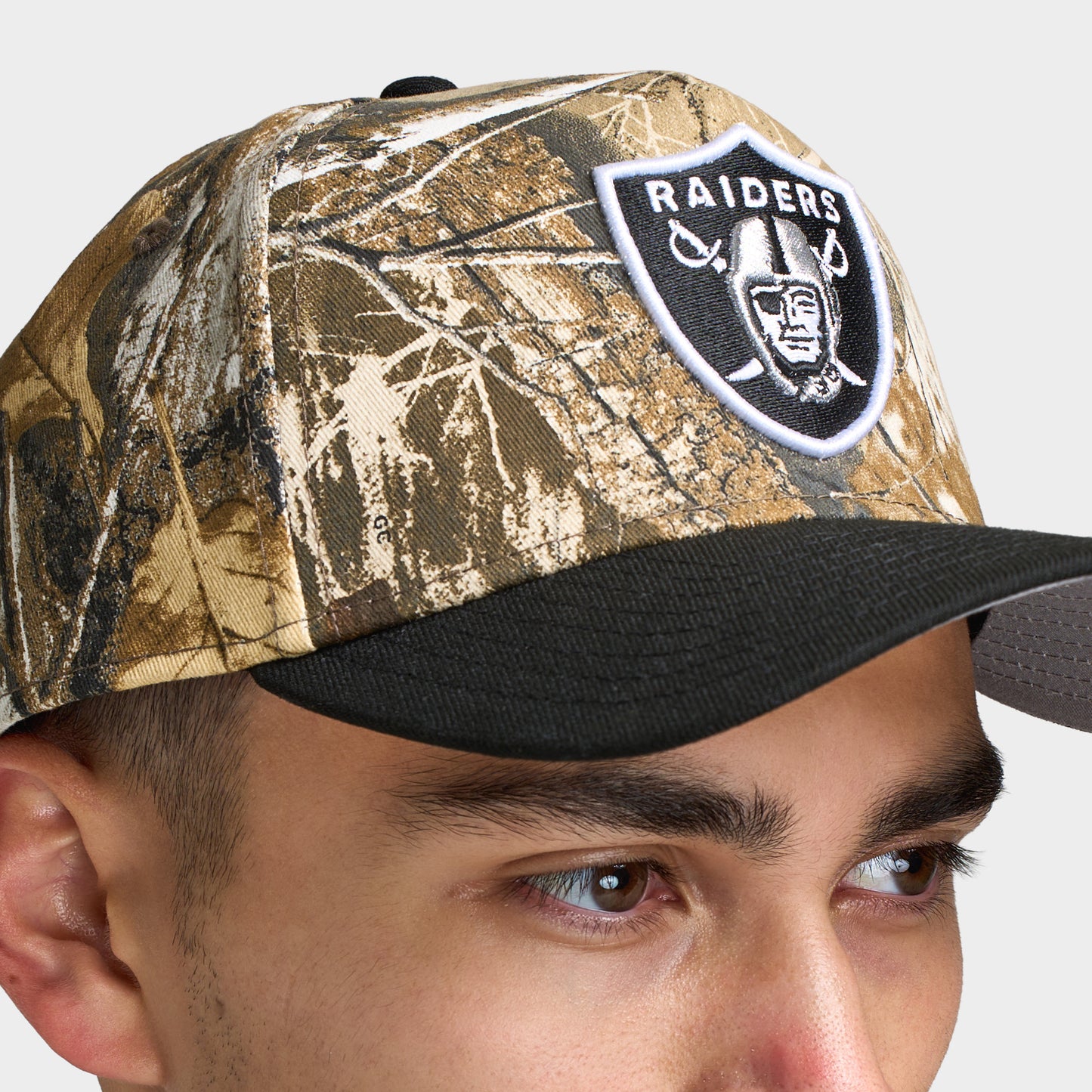 New Era Las Vegas Raiders 9FORTY A-Frame cap. Close-up front view showing the Realtree camo crown, curved black brim and Raiders shield logo patch.