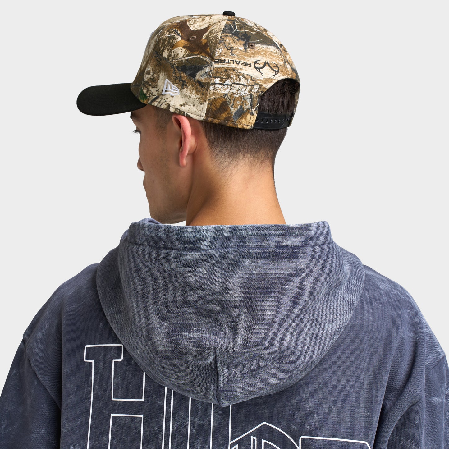 New Era Las Vegas Raiders 9FORTY A-Frame cap. Back view of model wearing the Realtree camo and black cap with curved brim and adjustable rear fit.