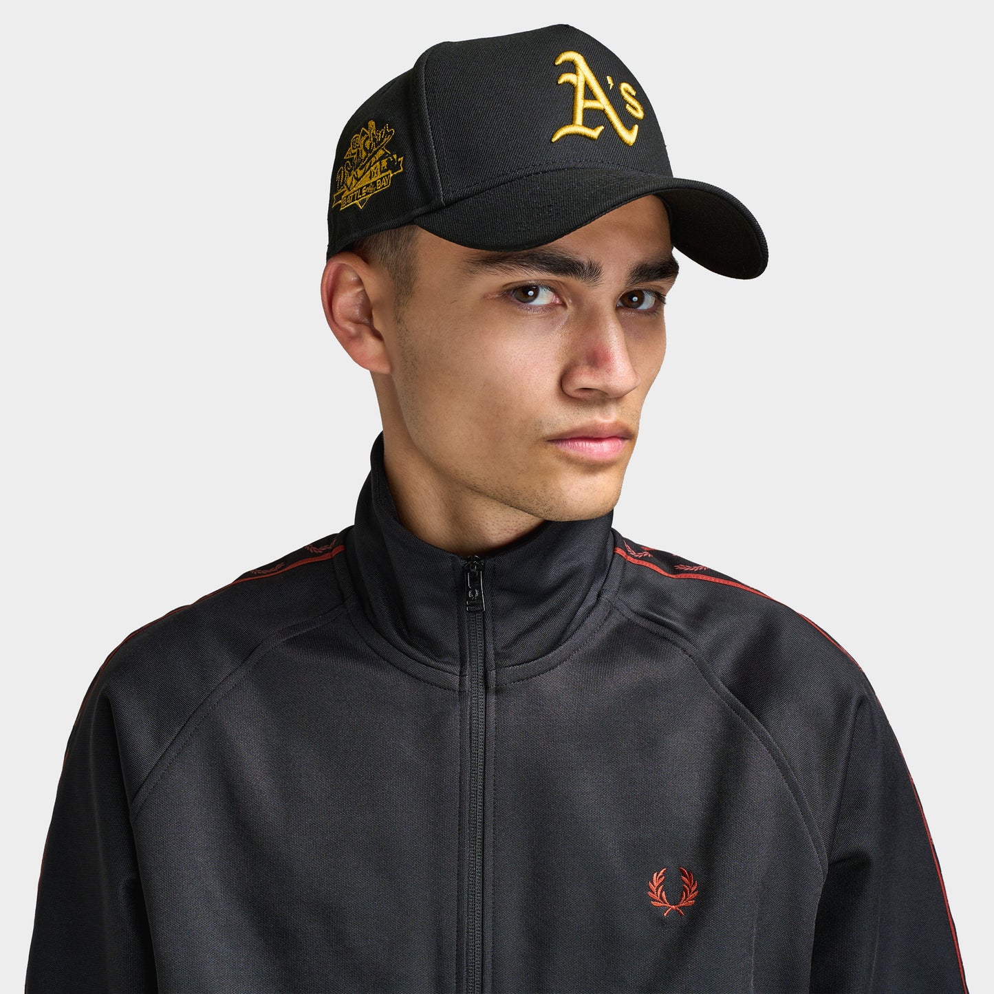 New Era Oakland Athletics 9FORTY AF Snapback. Front view of model wearing black cap with curved brim, gold Oakland Athletics logo and embroidered side patch.