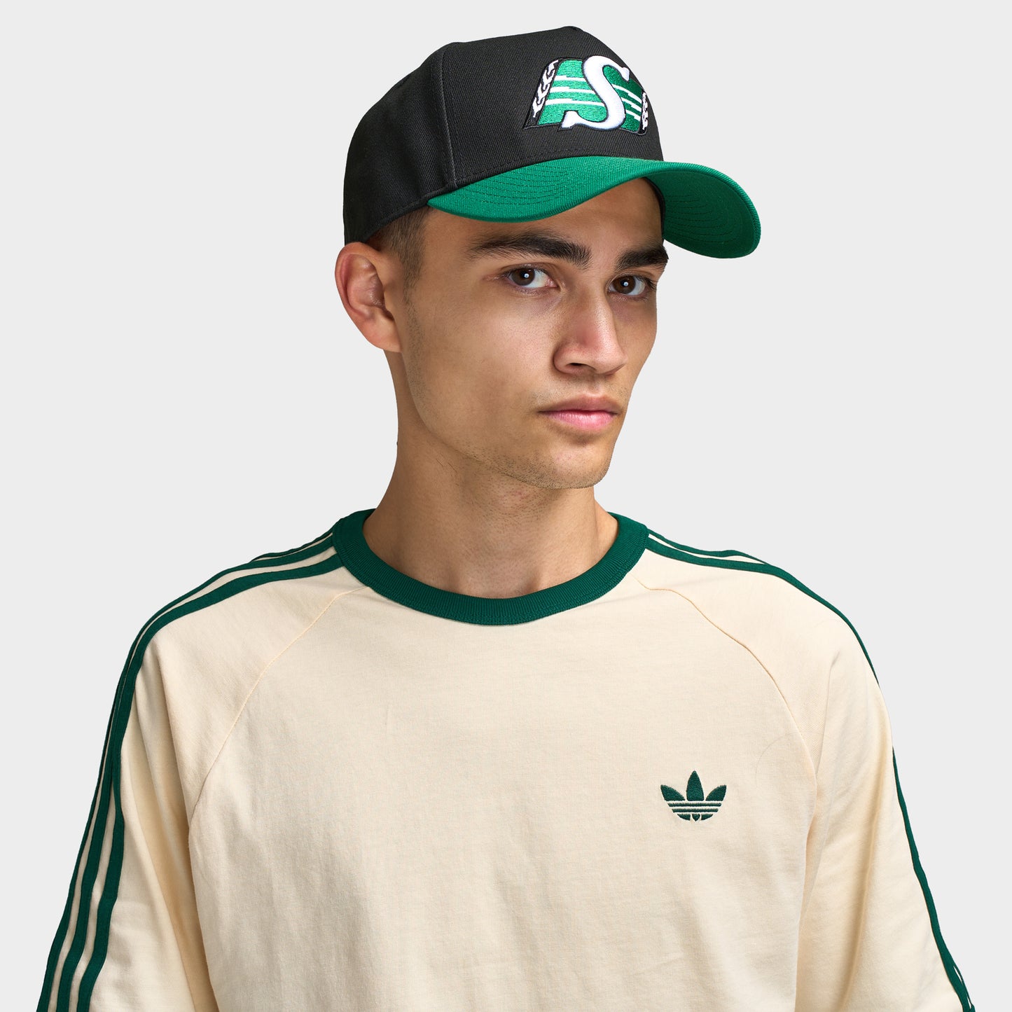 New Era Saskatchewan Roughriders 9FORTY AF. Front view of model wearing black and green cap with green curved brim and Saskatchewan Roughriders logo.