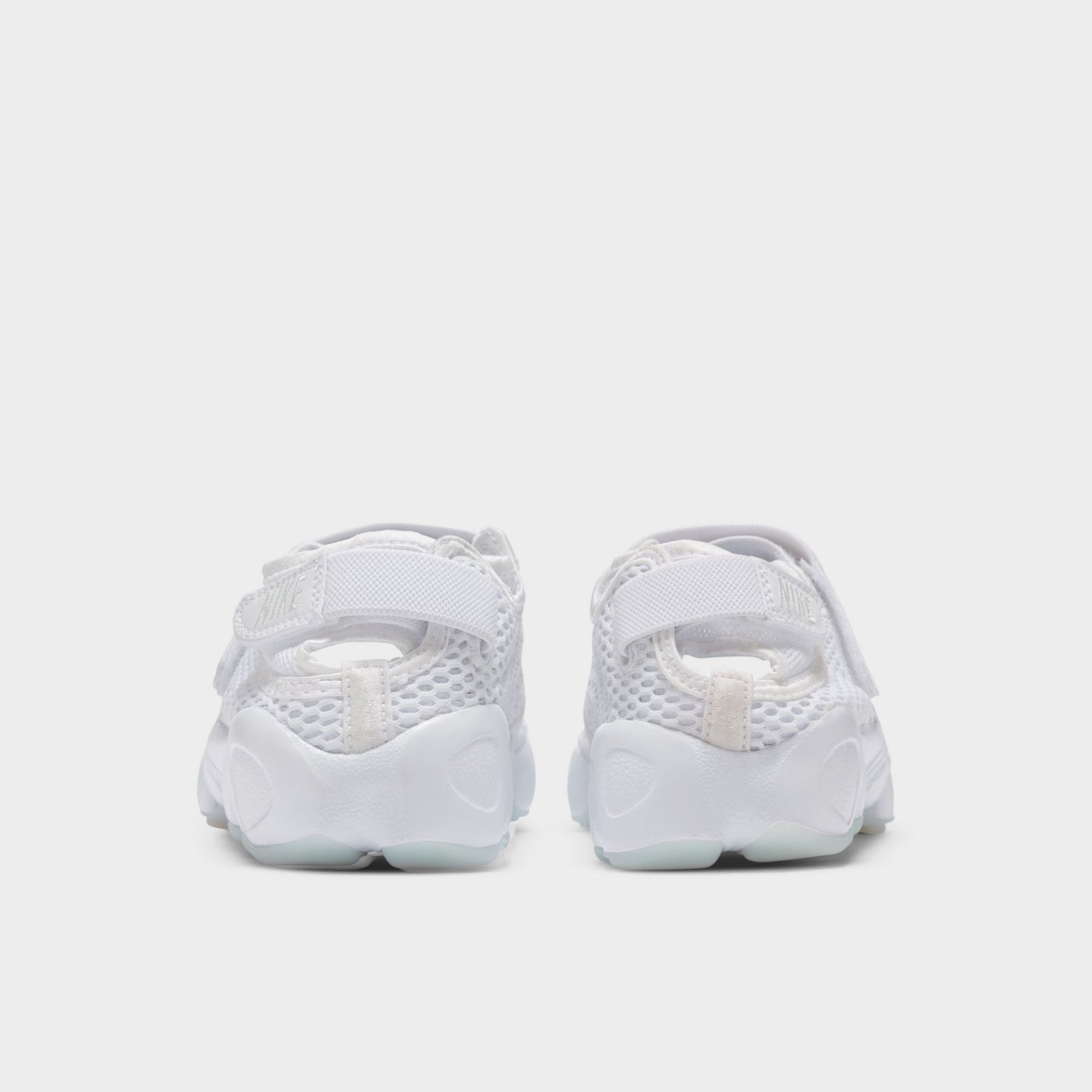 Nike Women's Air Rift Breathe. Rear view of white split-toe sneakers with adjustable heel straps and rounded soles.