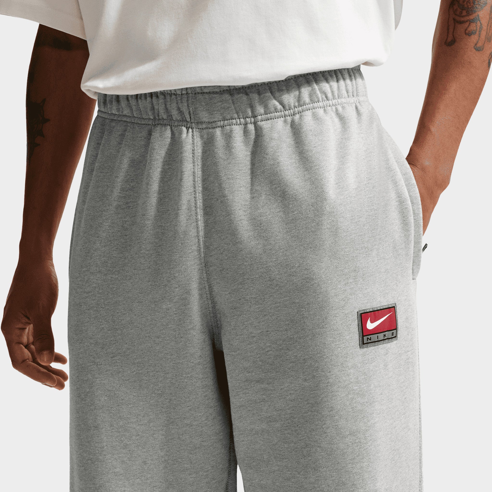 grey nike joggers with red tick
