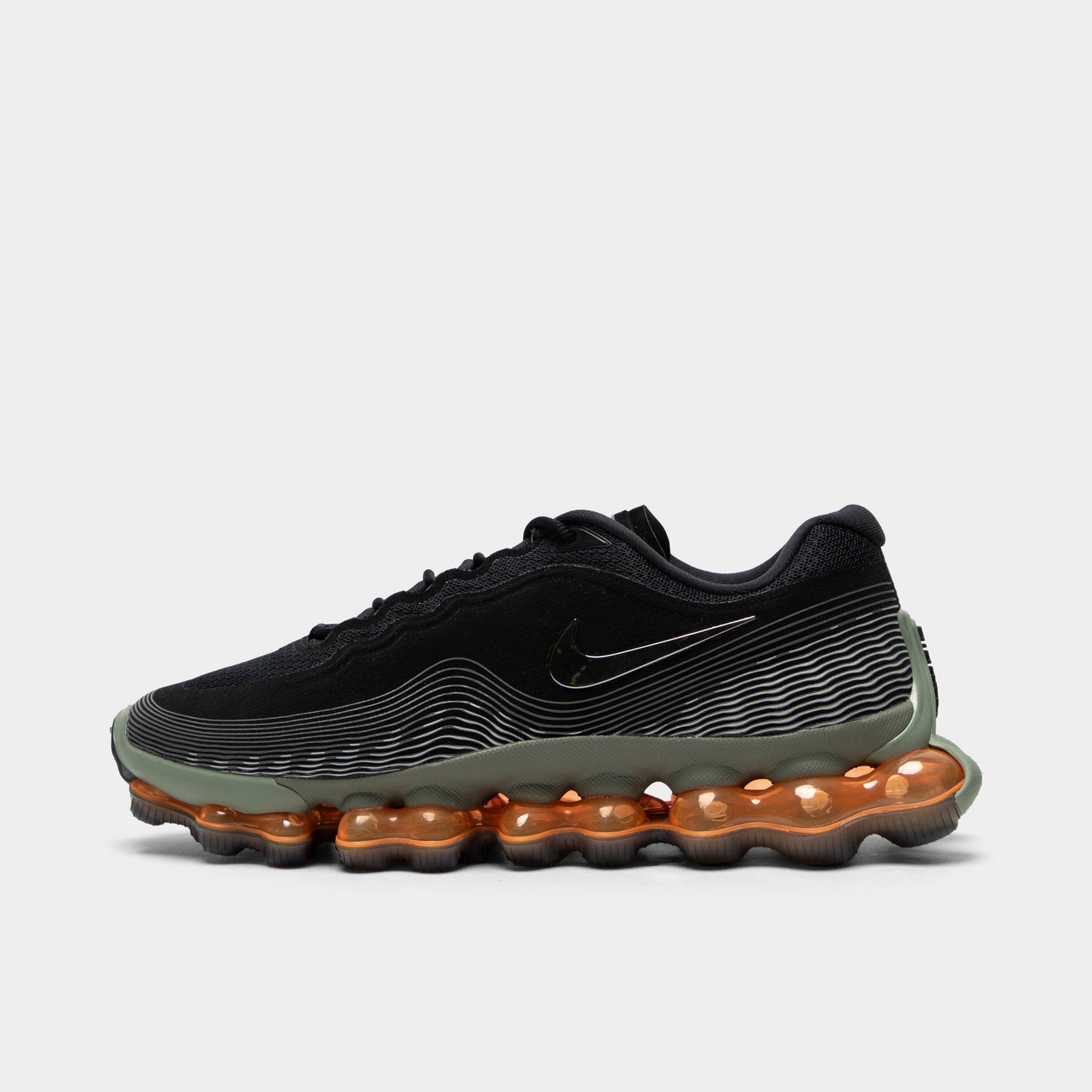 Nike Air Liquid Max. Side view of black, metallic silver and light army sneaker with wavy upper lines, tonal Swoosh and amber full-length Air sole.