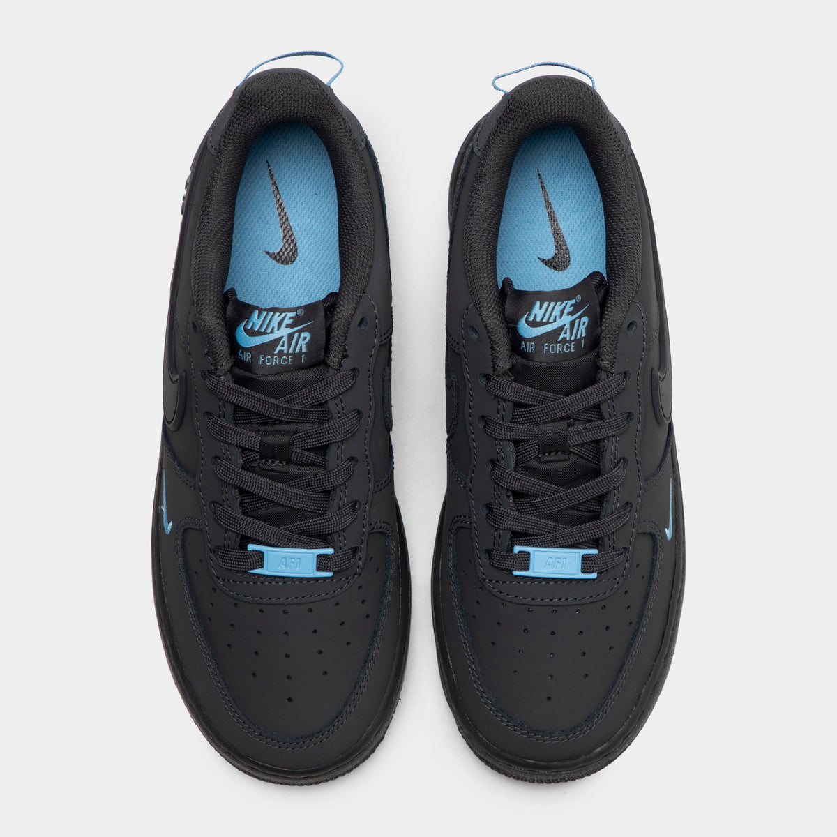 Nike Air Force 1 GS. Top-down overhead view of pair of low-top sneakers showing perforated anthracite toe boxes, tonal laces, football blue lace dubraes, and football blue insoles with Nike Air logos.