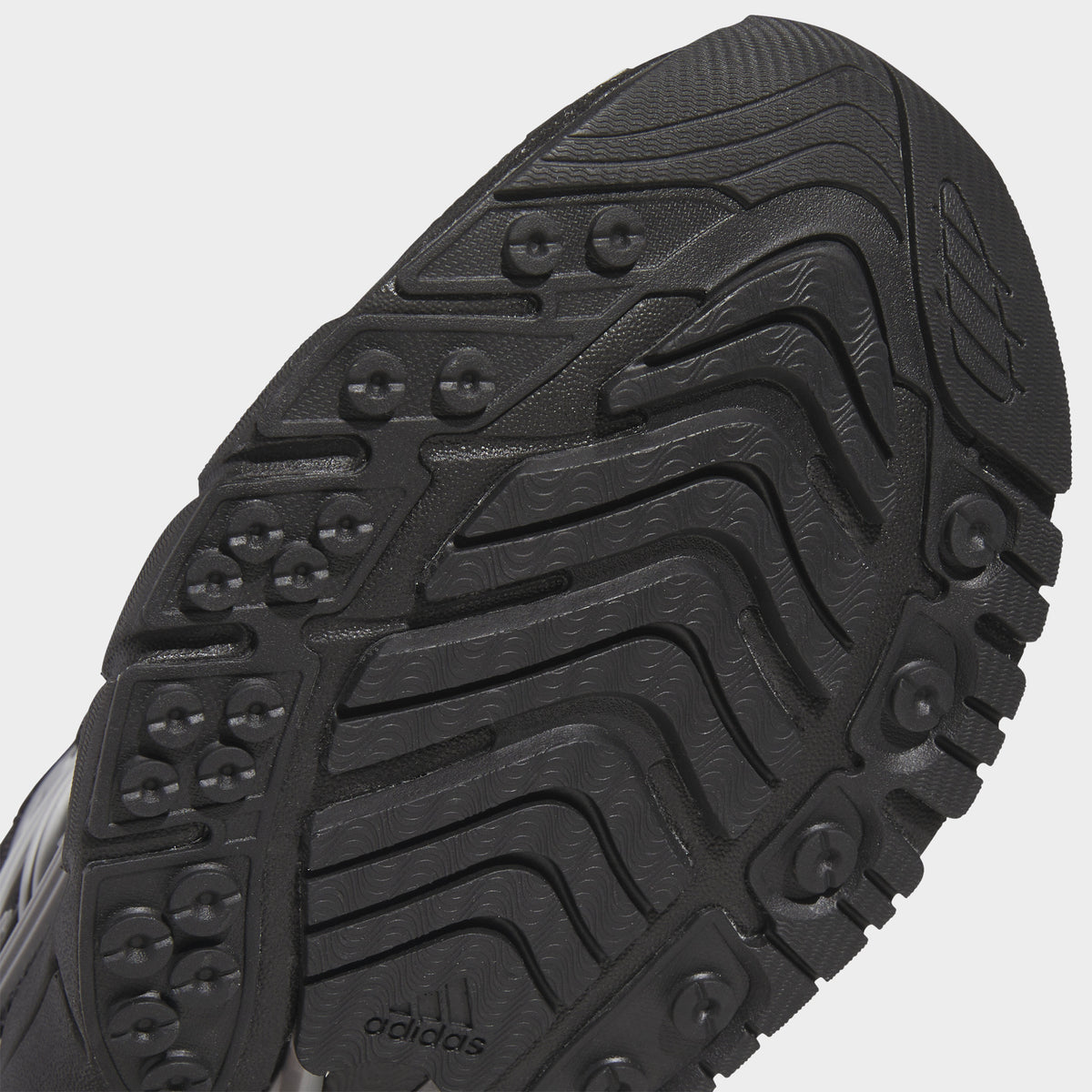 adidas Adistar XLG 2.0. Close-up of core black and iron metallic sneaker showing black outsole with curved grooves and textured tread.