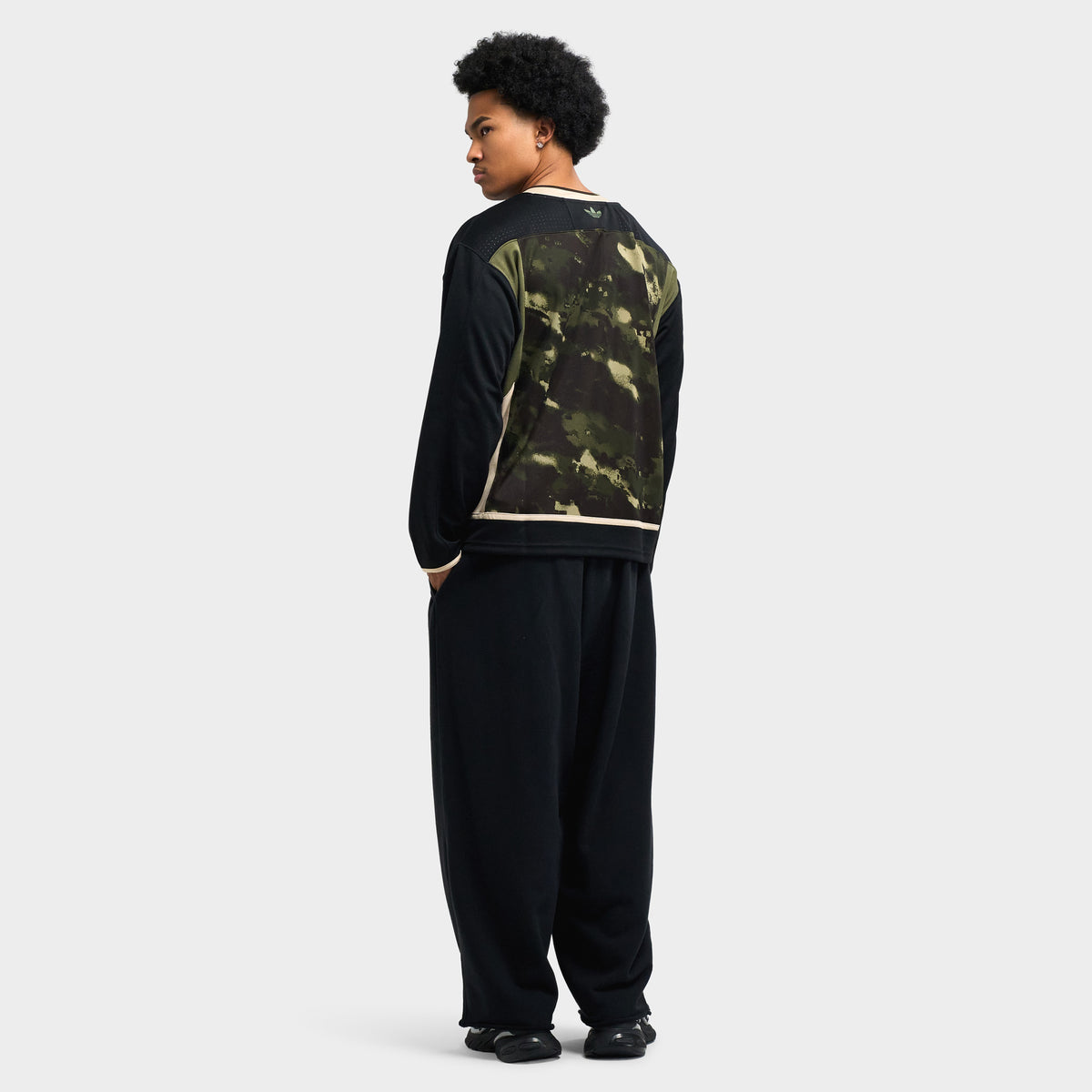 adidas Hockey Jersey. Full-length front view of model wearing gothic olive strata camo jersey styled with baggy black pants.