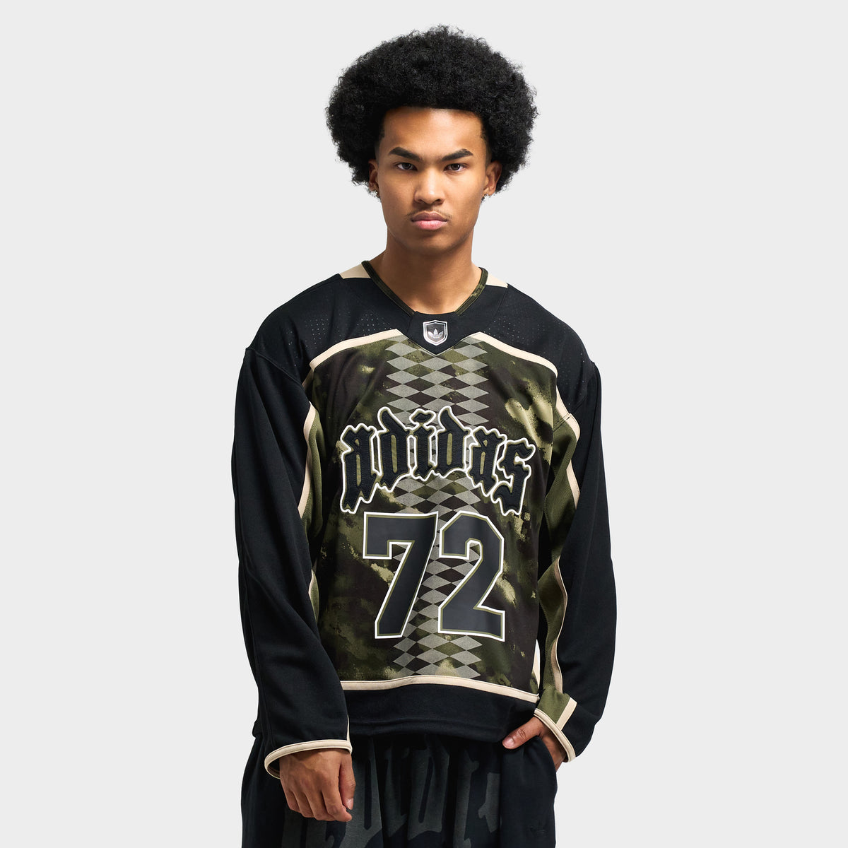 adidas Hockey Jersey. Olive strata camo print mesh hockey jersey featuring V-neck insert, black sleeves, cream trim, gothic "adidas" font, and large "72" front graphic.