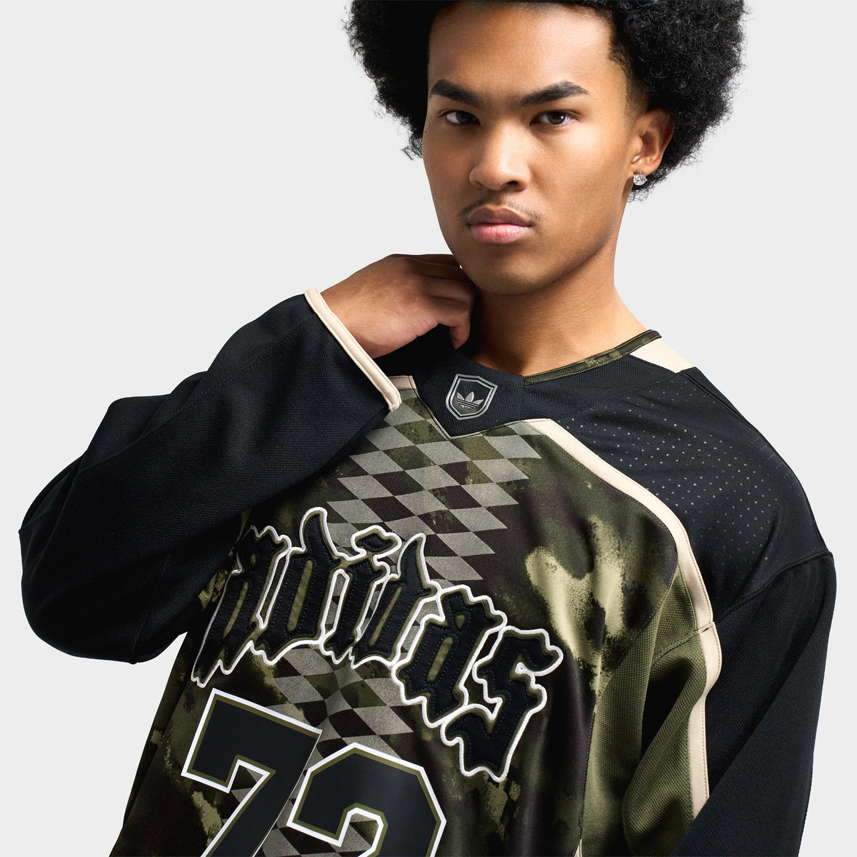 adidas Hockey Jersey. Close-up view highlighting ribbed V-neck collar with center NHL-style shield patch, gothic "adidas" chest script, and "72" front graphic print.