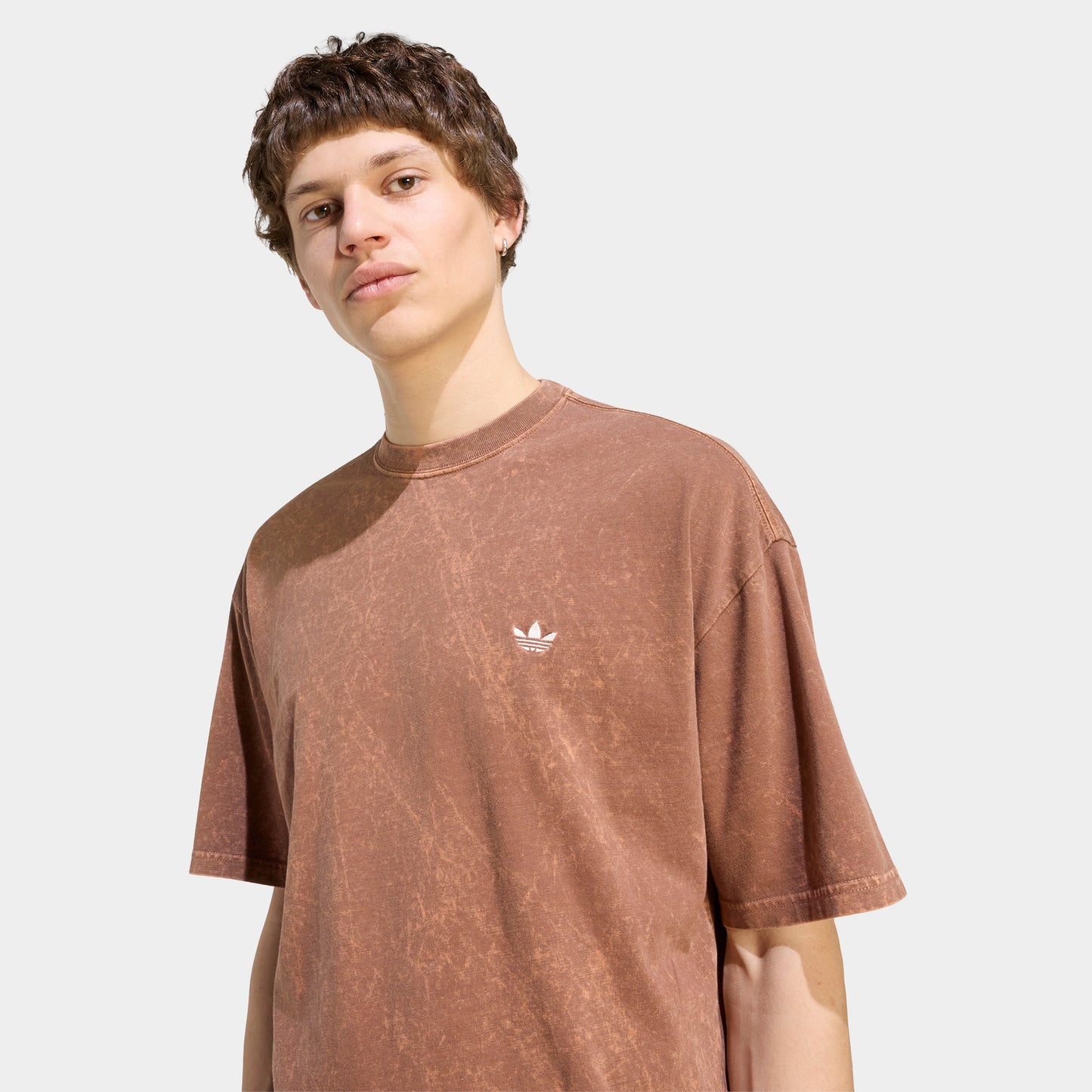 adidas Trefoil Essential Washed Loose T-Shirt. Three-quarter view of model wearing preloved brown T-shirt with washed finish and small white Trefoil chest logo.