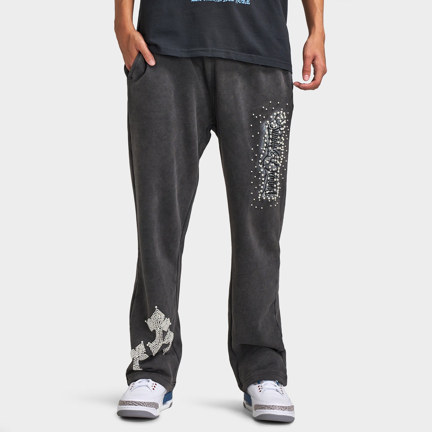 Supply & Demand Murphy Oversized Pants. Front view of model wearing black oversized pants with wide legs, washed finish and large white graphic details.
