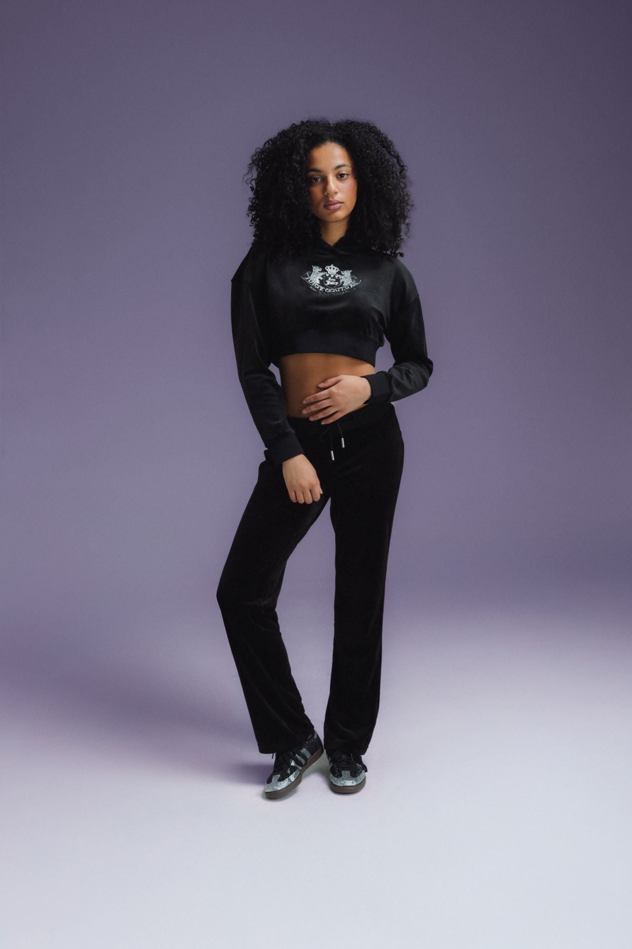 La femme porte le chandail Juicy Couture Luxe Velour Cropped « Réglisse ». Magasinez All Things Shiny dès maintenant chez JD Sports