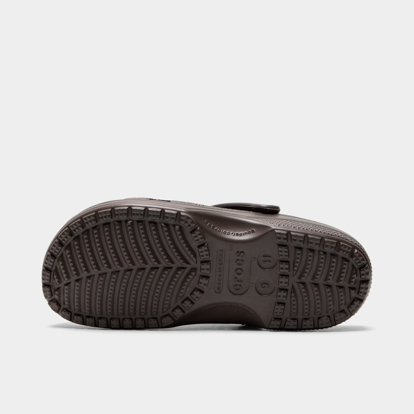 Crocs Classic Clog. Bottom view of espresso clog showing textured outsole with segmented tread pattern.