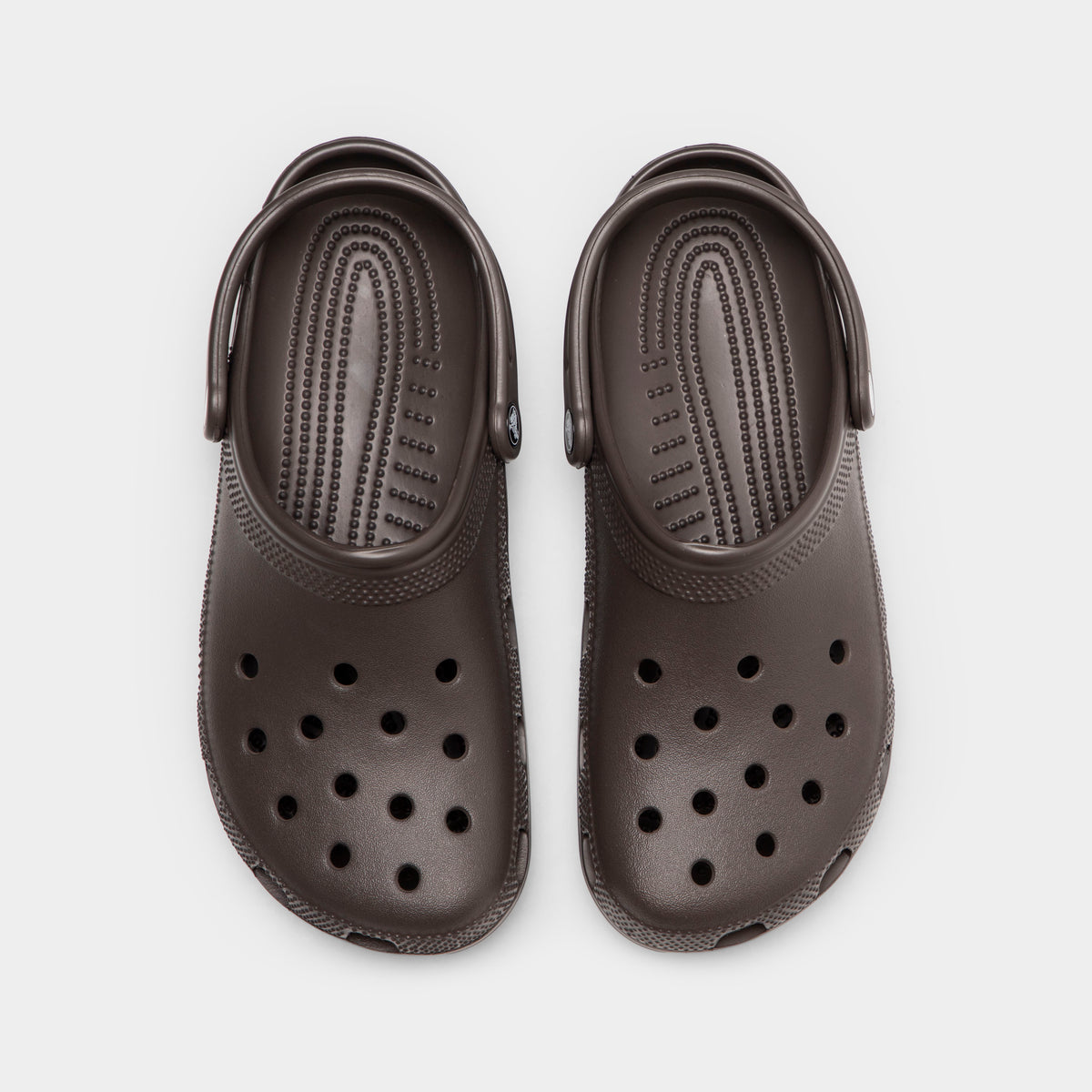 Crocs Classic Clog. Top view of espresso clogs showing ventilation holes, rounded toe boxes and pivoting heel straps.