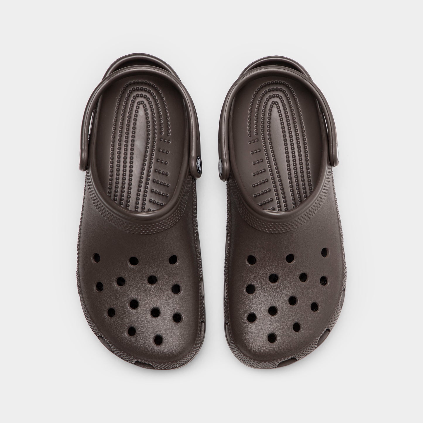 Crocs Classic Clog. Top view of espresso clogs showing ventilation holes, rounded toe boxes and pivoting heel straps.