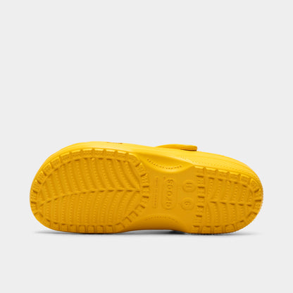 Crocs Classic Clog. Bottom view of golden light clog showing textured outsole with segmented tread pattern.