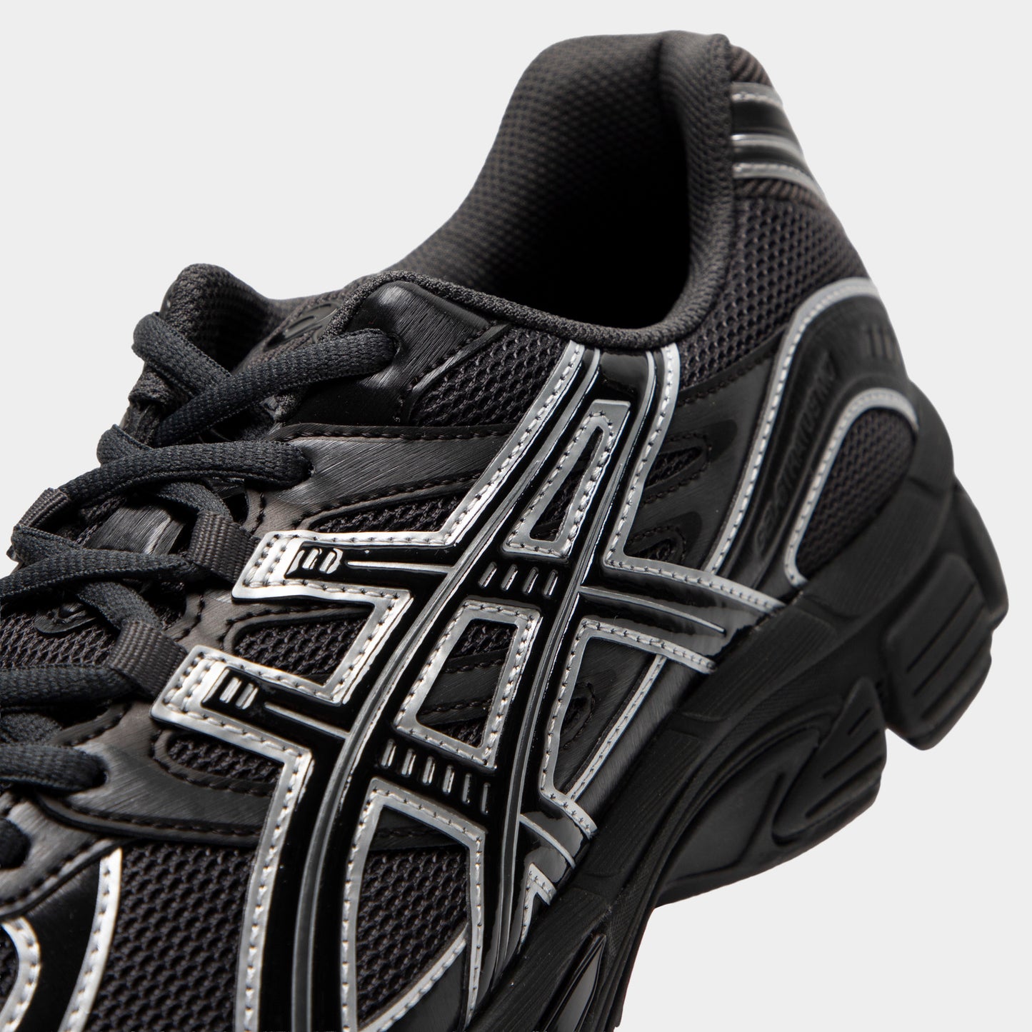 ASICS Gel-Stratus MC. Close-up of graphite grey and black sneaker showing black laces, mesh panels and grey ASICS stripes.