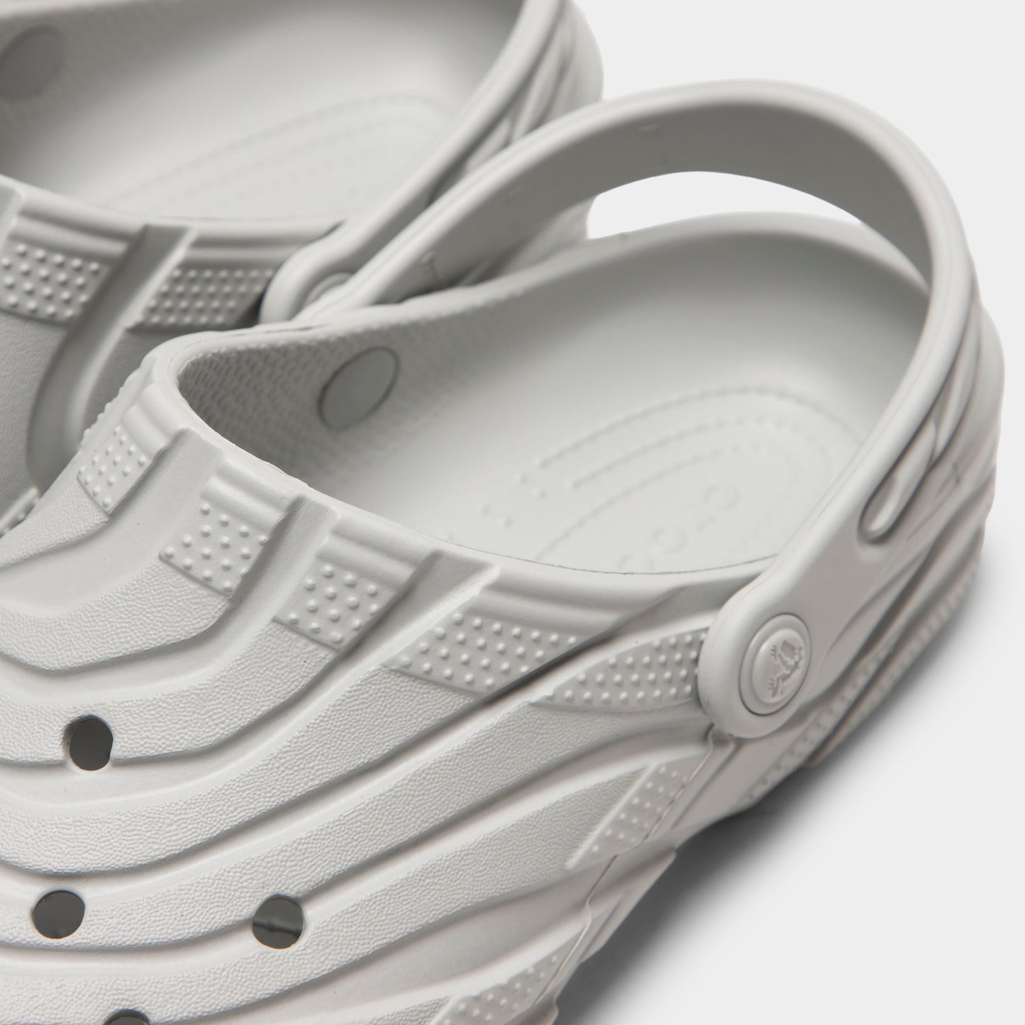 Crocs Classic Erosion Clog. Close-up of atmosphere clog showing pivoting heel strap, Crocs logo button, sculpted side panels and ventilation holes.