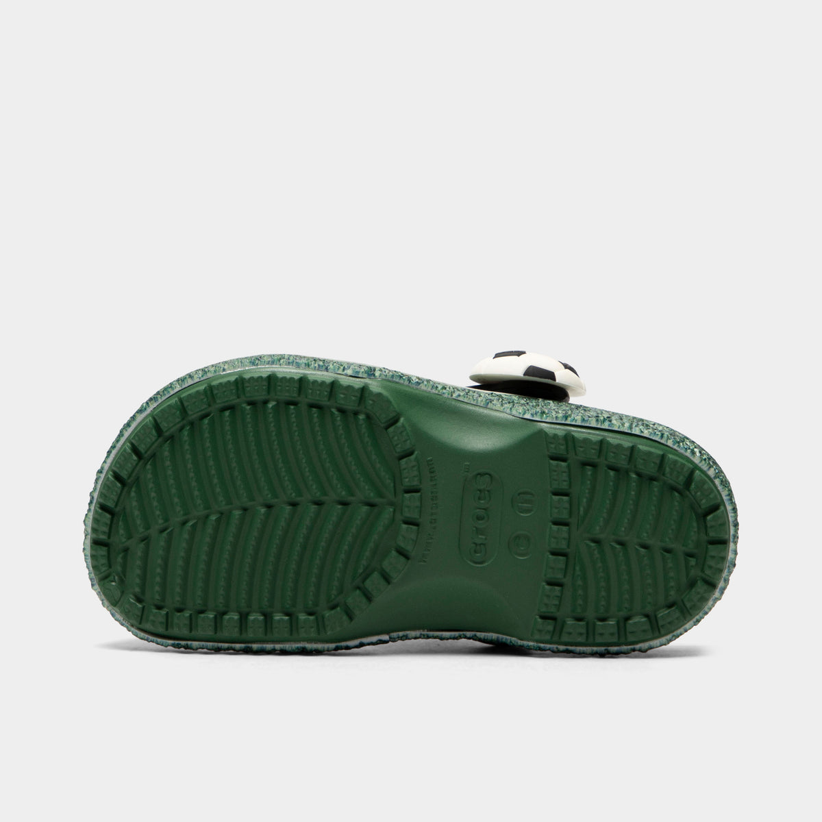 Crocs Kids' Classic Funlab Clog. Bottom view of turf green infant clog showing textured outsole with segmented tread pattern.
