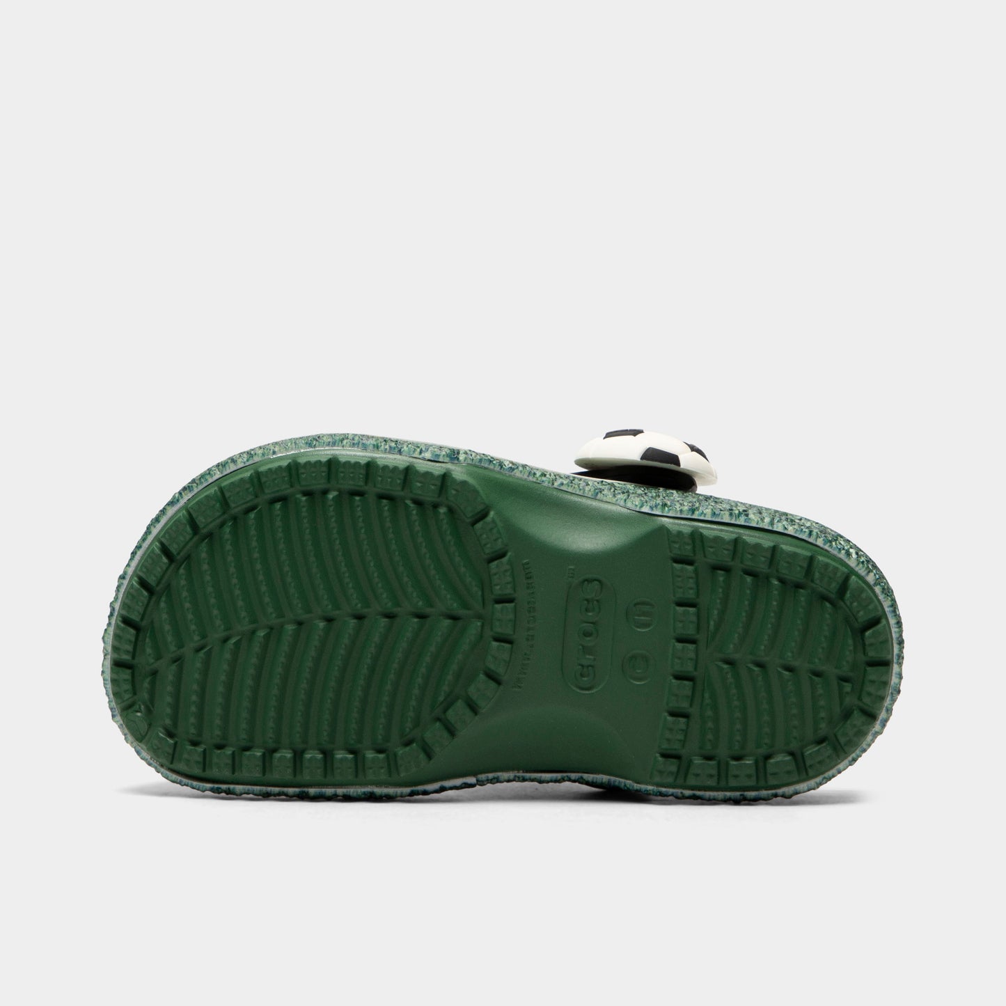 Crocs Kids' Classic Funlab Clog. Bottom view of turf green infant clog showing textured outsole with segmented tread pattern.