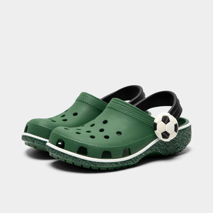 Crocs Kids' Classic Funlab Clog. Three-quarter view of turf green infant clogs with ventilation holes, raised heel straps and soccer-inspired details.