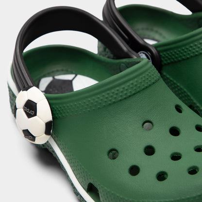 Crocs Kids' Classic Funlab Clog. Close-up of turf green infant clog showing black pivoting heel strap, soccer ball detail and ventilation holes.