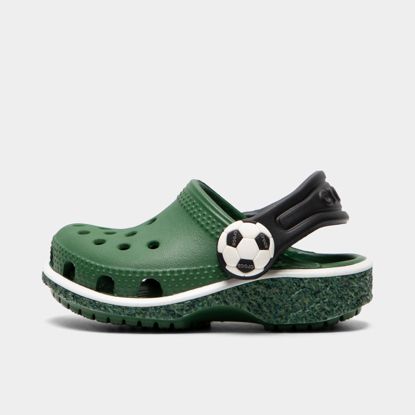 Crocs Infants' Classic Funlab Clog. Side view of turf green infant clog with ventilation holes, black heel strap and soccer ball detail.