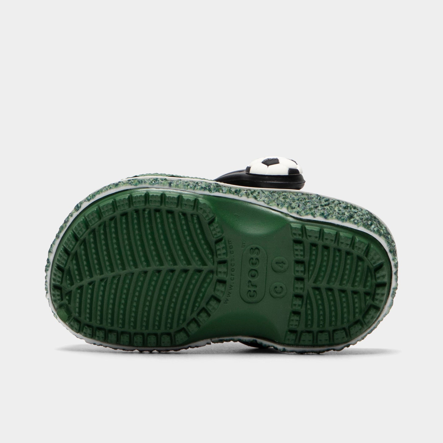 Crocs Infants' Classic Funlab Clog. Bottom view of turf green infant clog showing textured outsole with segmented tread pattern.