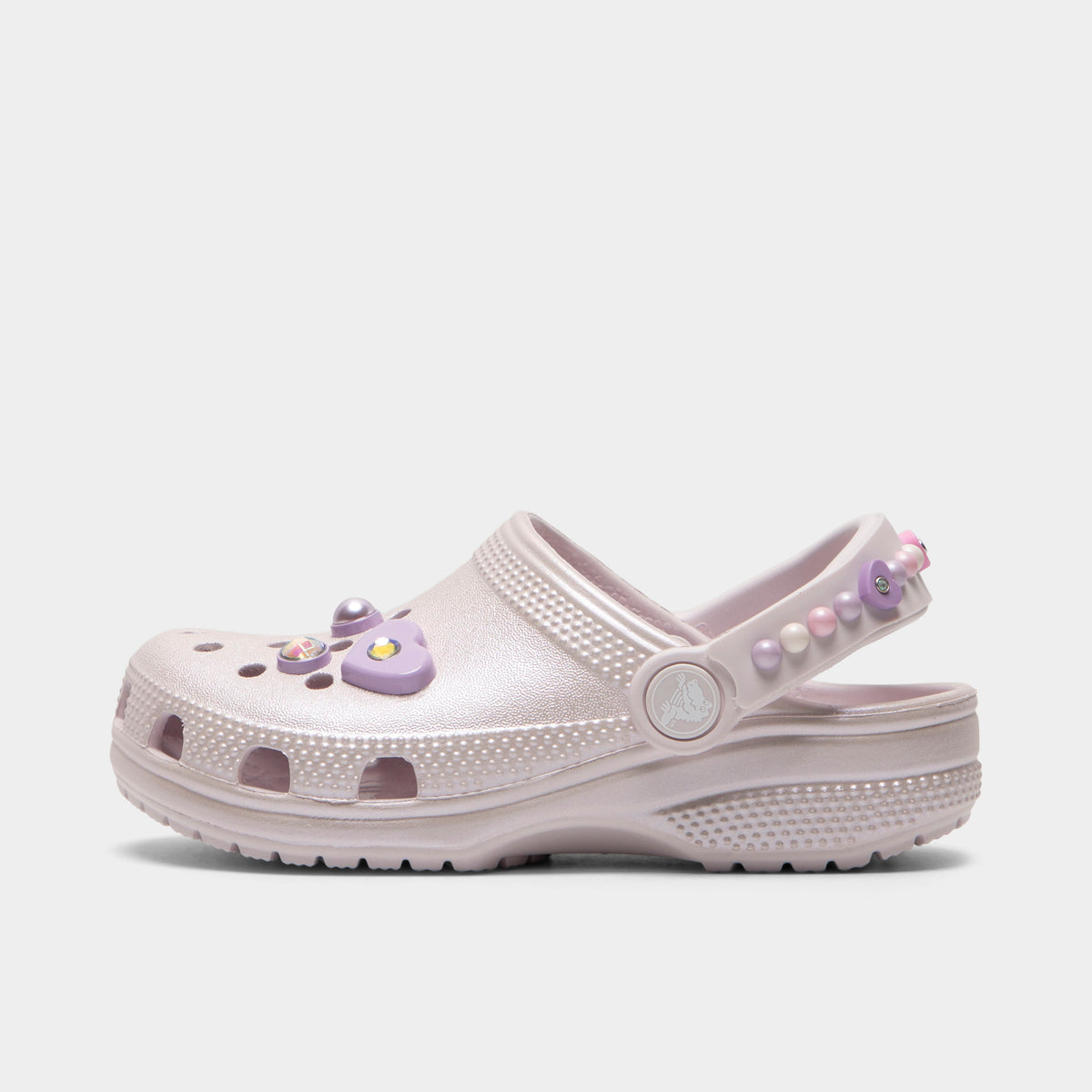Crocs Kids' Classic Pearls and Heart Shine Clog. Side view of grape ice infant clog with ventilation holes, pivoting heel strap and decorative pearl and heart charms.
