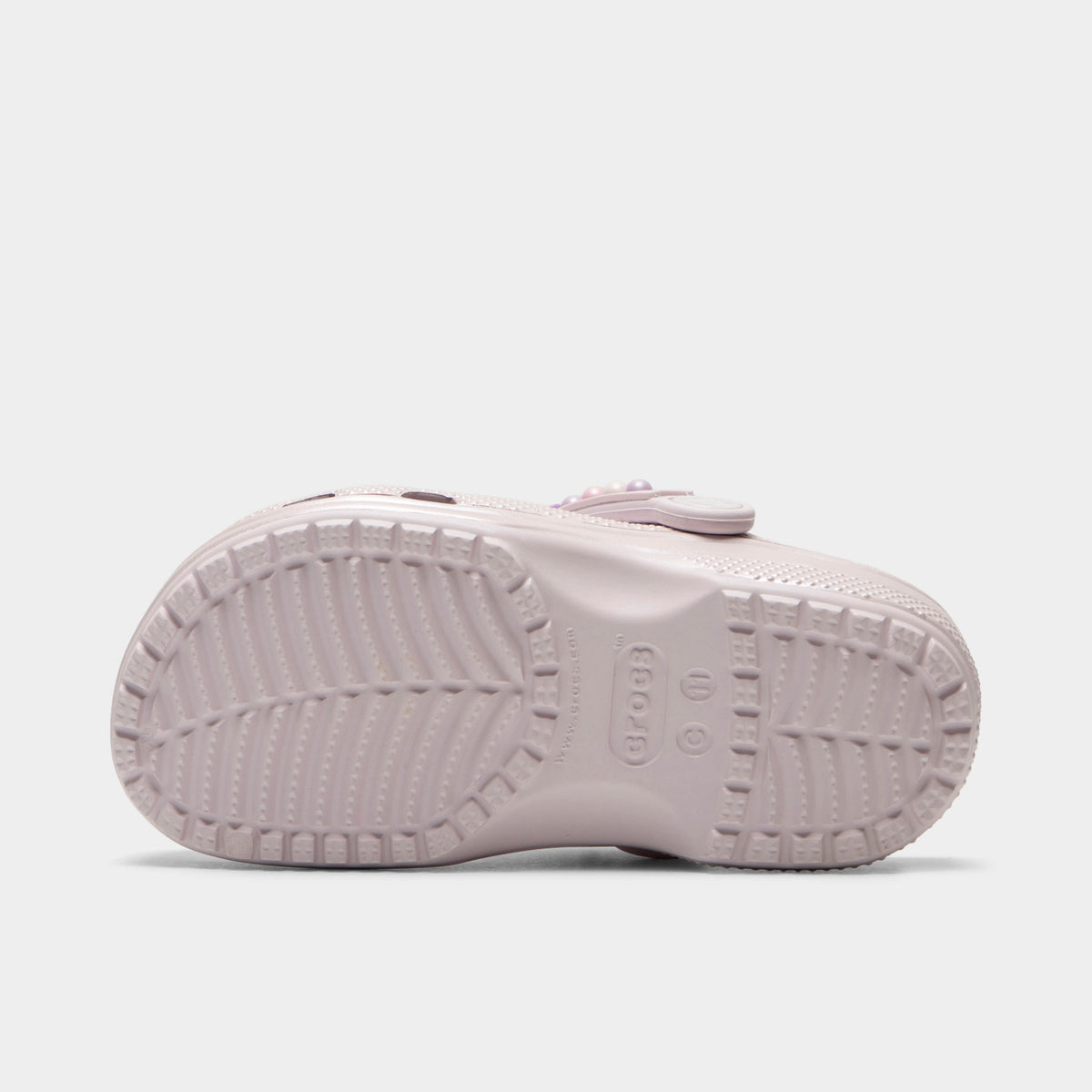 Crocs Kids' Classic Pearls and Heart Shine Clog. Bottom view of grape ice infant clog showing textured outsole with segmented tread pattern.