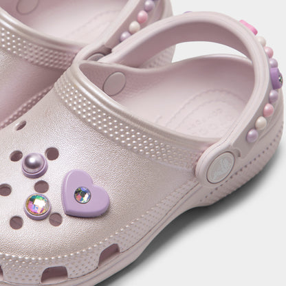 Crocs Kids' Classic Pearls and Heart Shine Clog. Close-up of grape ice infant clog showing pivoting heel strap, pearl and heart charms and Crocs logo button.