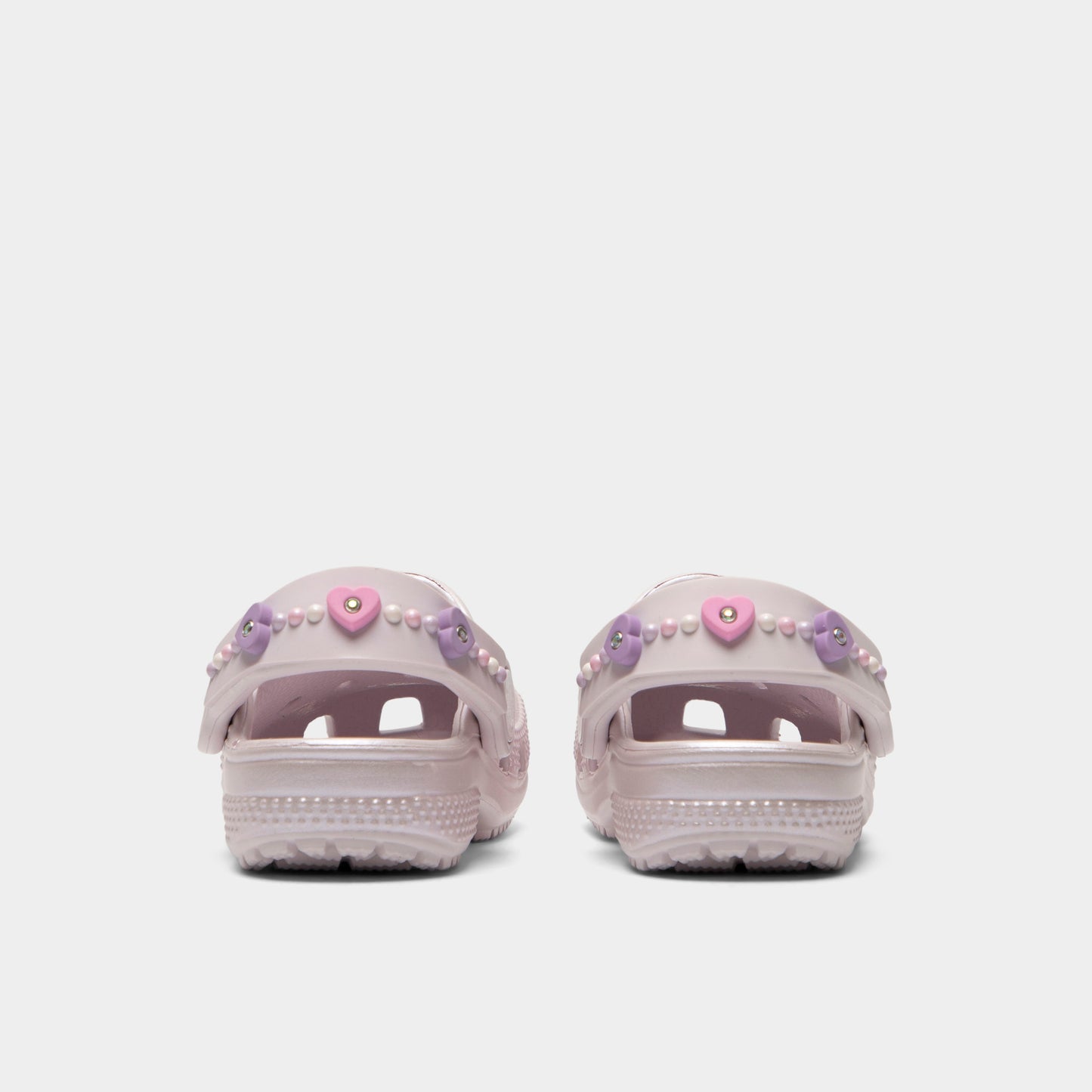 Crocs Infants' Classic Pearls and Heart Shine Clog. Rear view of grape ice infant clogs with lowered heel straps, rounded heels and matching soles.