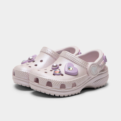 Crocs Infants' Classic Pearls and Heart Shine Clog. Three-quarter view of grape ice infant clogs with ventilation holes, raised heel straps and decorative charms.