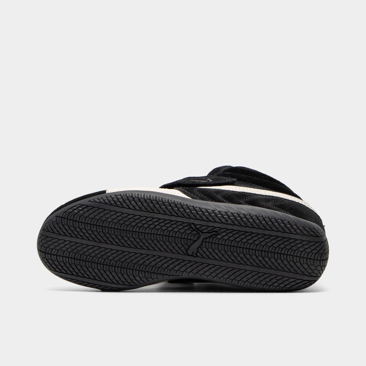 Puma Women's Speedcat Wedge. Bottom view of black and white wedge sneaker showing black outsole with textured tread pattern.