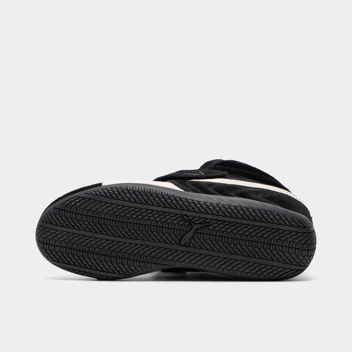 Puma Women's Speedcat Wedge. Bottom view of black and white wedge sneaker showing black outsole with textured tread pattern.