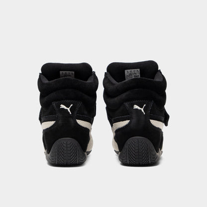Puma Women's Speedcat Wedge. Rear view of black and white wedge sneakers with padded heel panels, pull tabs and black soles.