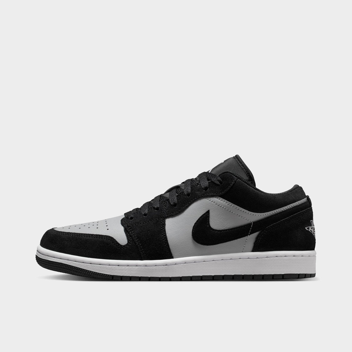 Jordan 1 Low. Side view of black, white and light smoke grey sneaker with black overlays, grey Swoosh and white midsole.