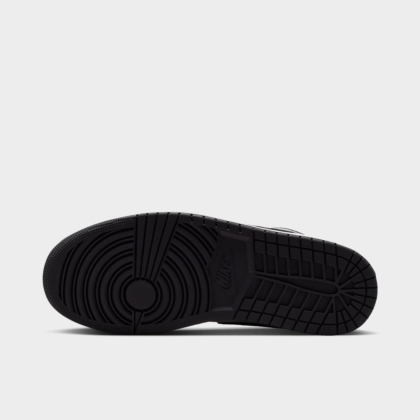 Jordan 1 Low. Bottom view of black, white and light smoke grey sneaker showing black outsole with circular forefoot tread.