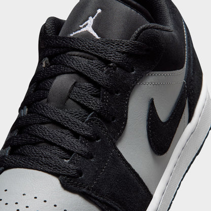 Jordan 1 Low. Close-up of black, white and light smoke grey sneaker showing black laces, perforated white toe box and grey Swoosh.
