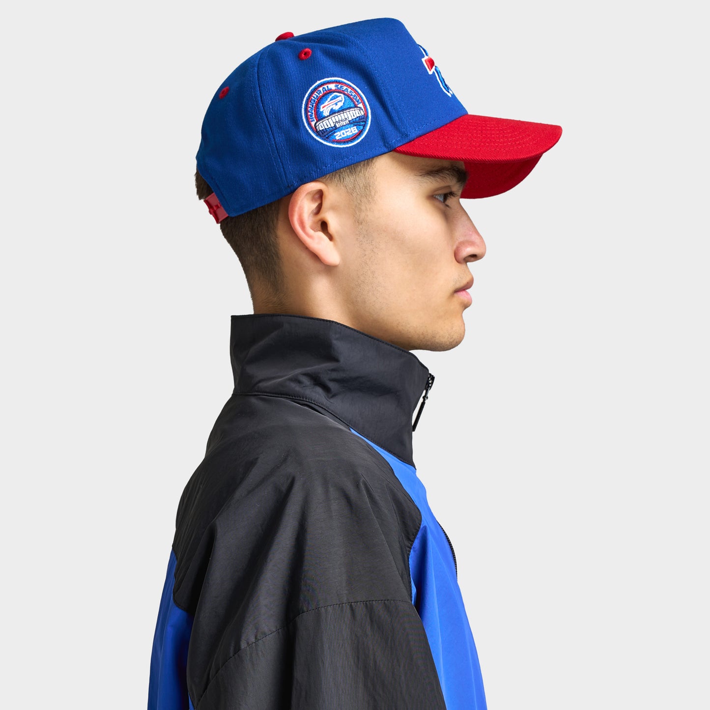 New Era Buffalo Bills 9FORTY AF. Side view of model wearing royal and red cap with red curved brim, Buffalo Bills side patch and structured profile.