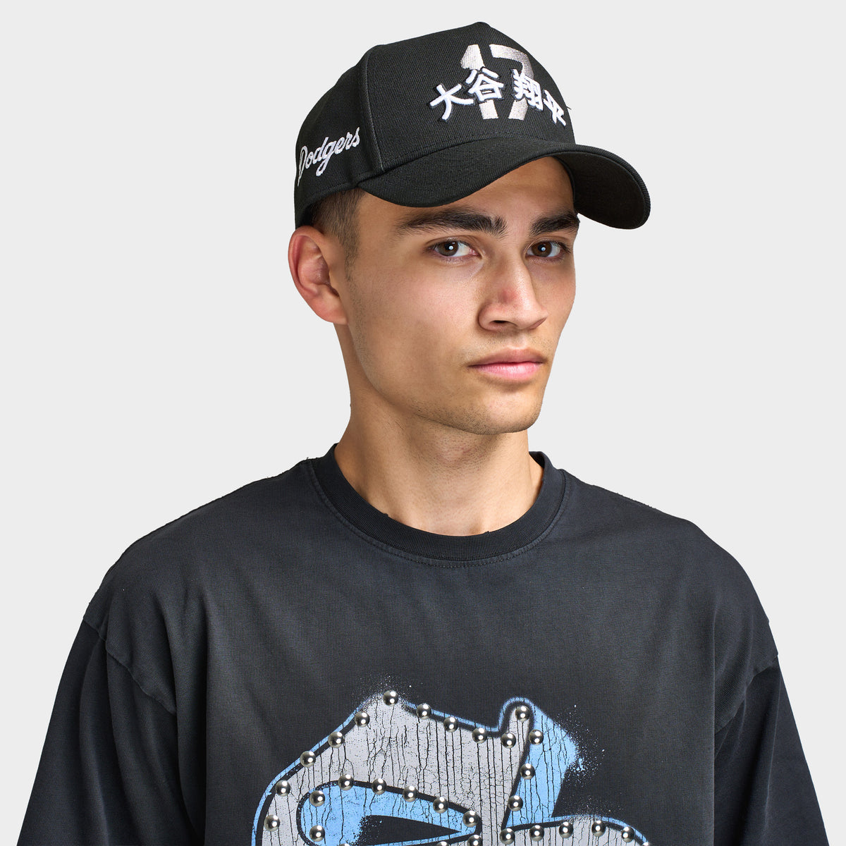 New Era LA Dodgers Shohei 9FORTY AF Snapback. Front view of model wearing black cap with curved brim, white Shohei-inspired graphic and embroidered side details.