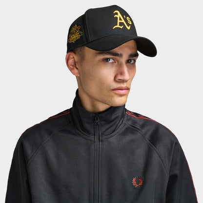 New Era Oakland Athletics 9FORTY AF Snapback. Front view of model wearing black cap with curved brim, gold Oakland Athletics logo and embroidered side patch.