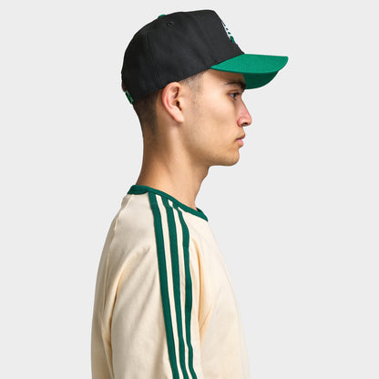New Era Saskatchewan Roughriders 9FORTY AF. Side view of model wearing black and green cap with green curved brim and structured profile.