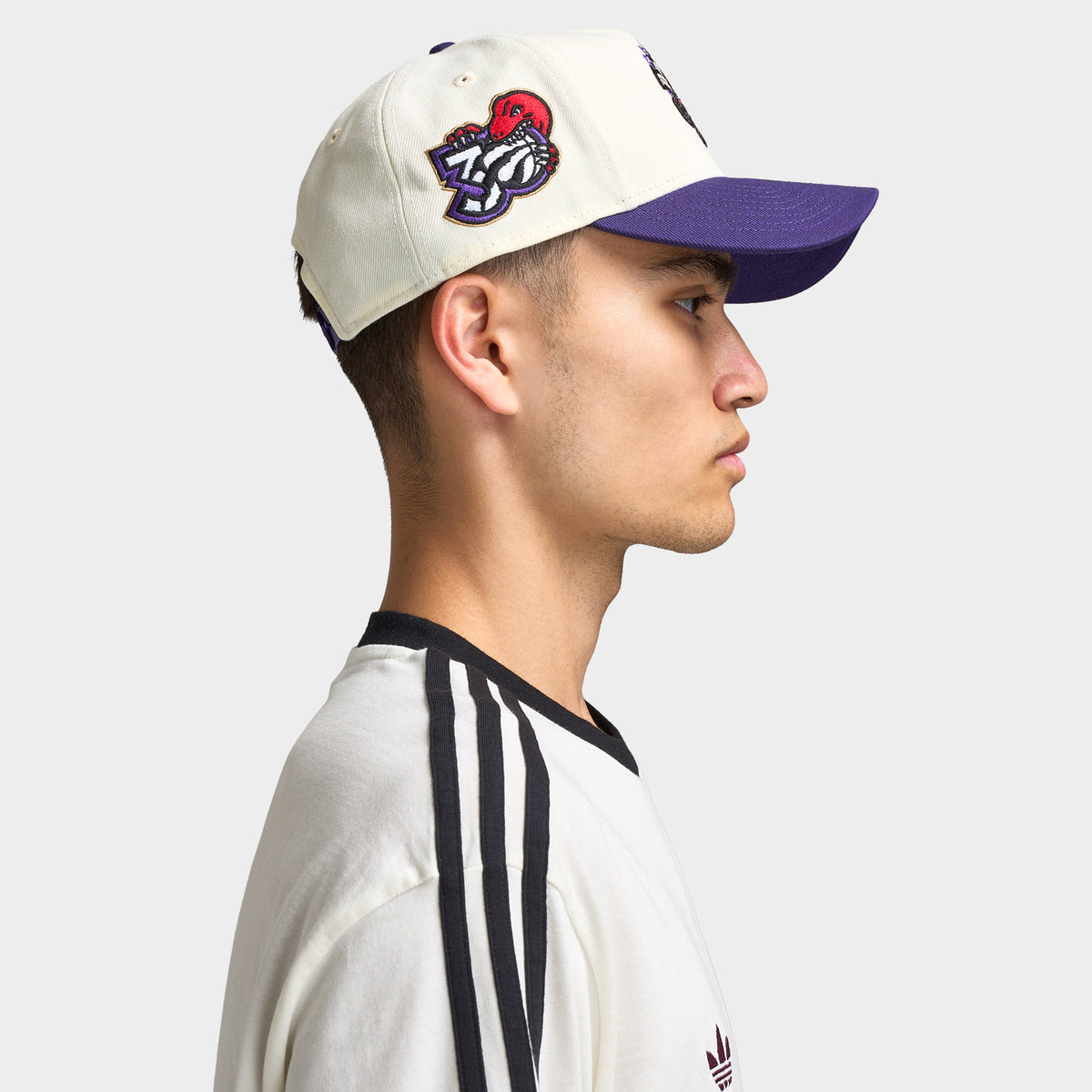 New Era Toronto Raptors 9FORTY AF. Side view of model wearing chrome and purple cap with curved brim, Toronto Raptors side patch and structured profile.