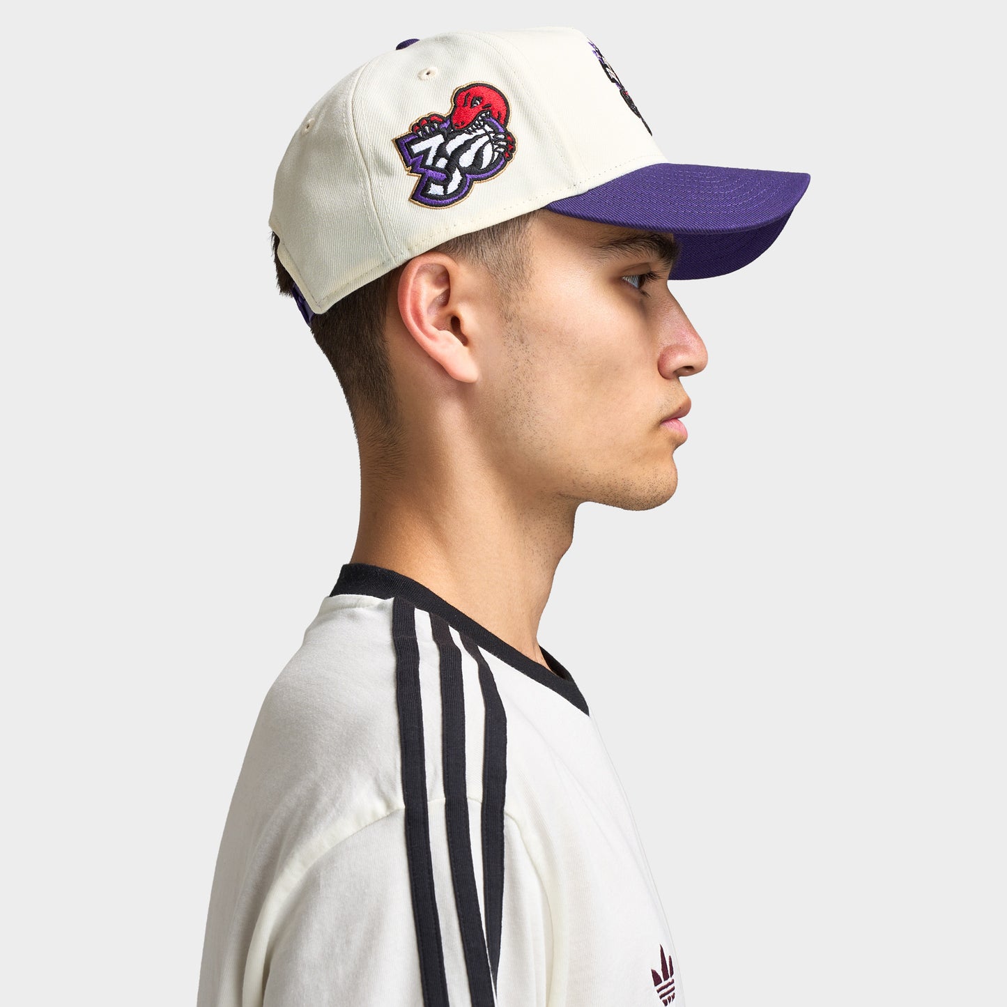 New Era Toronto Raptors 9FORTY AF. Side view of model wearing chrome and purple cap with curved brim, Toronto Raptors side patch and structured profile.