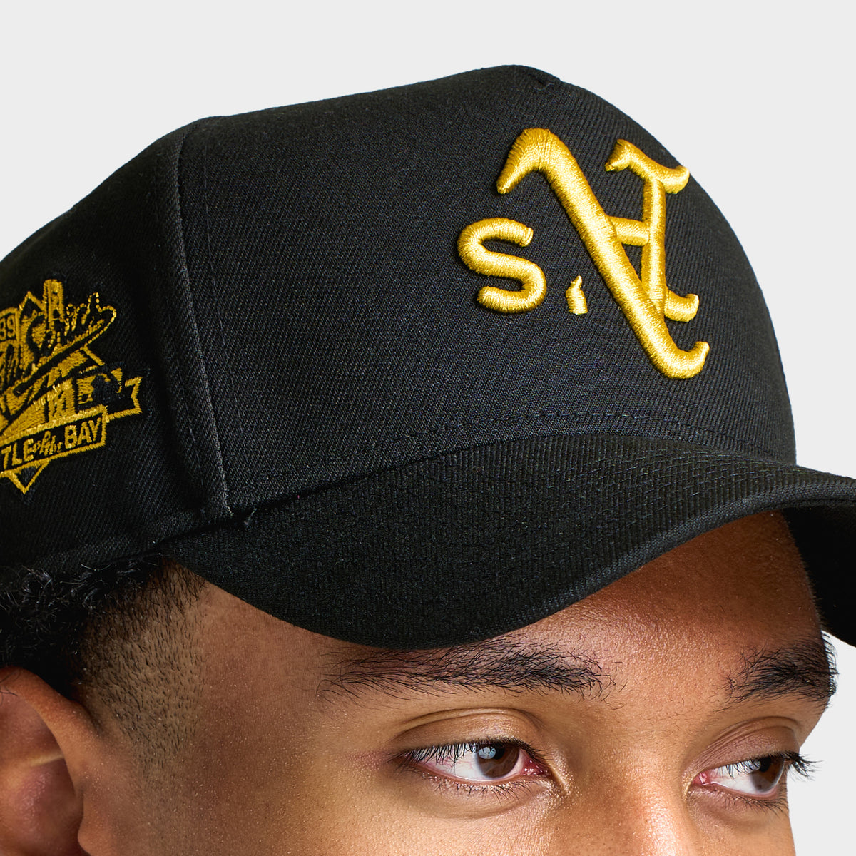 New Era Oakland Athletics Upside Down 9FORTY A-Frame. Close-up view highlighting the upside-down yellow A's logo embroidery, black crown, and gold commemorative side patch.