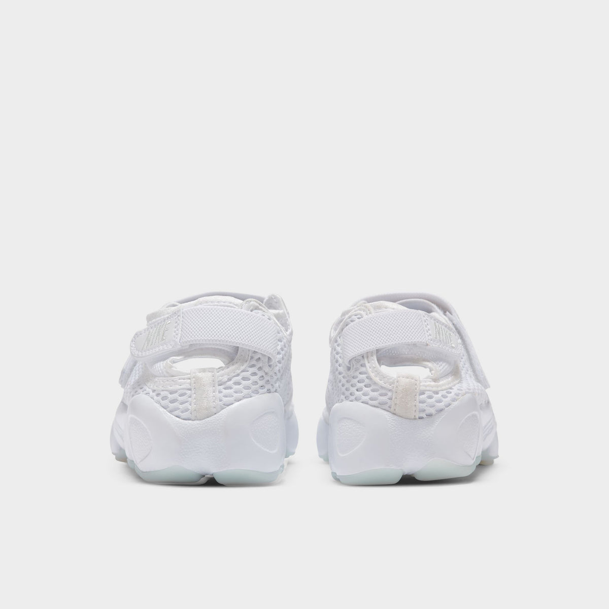 Nike Women's Air Rift Breathe. Rear view of white split-toe sneakers with adjustable heel straps and rounded soles.