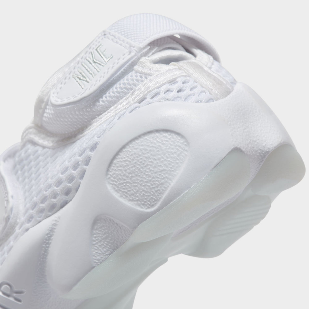 Nike Women's Air Rift Breathe. Close-up of white split-toe sneaker showing rounded outsole pods and sculpted heel.