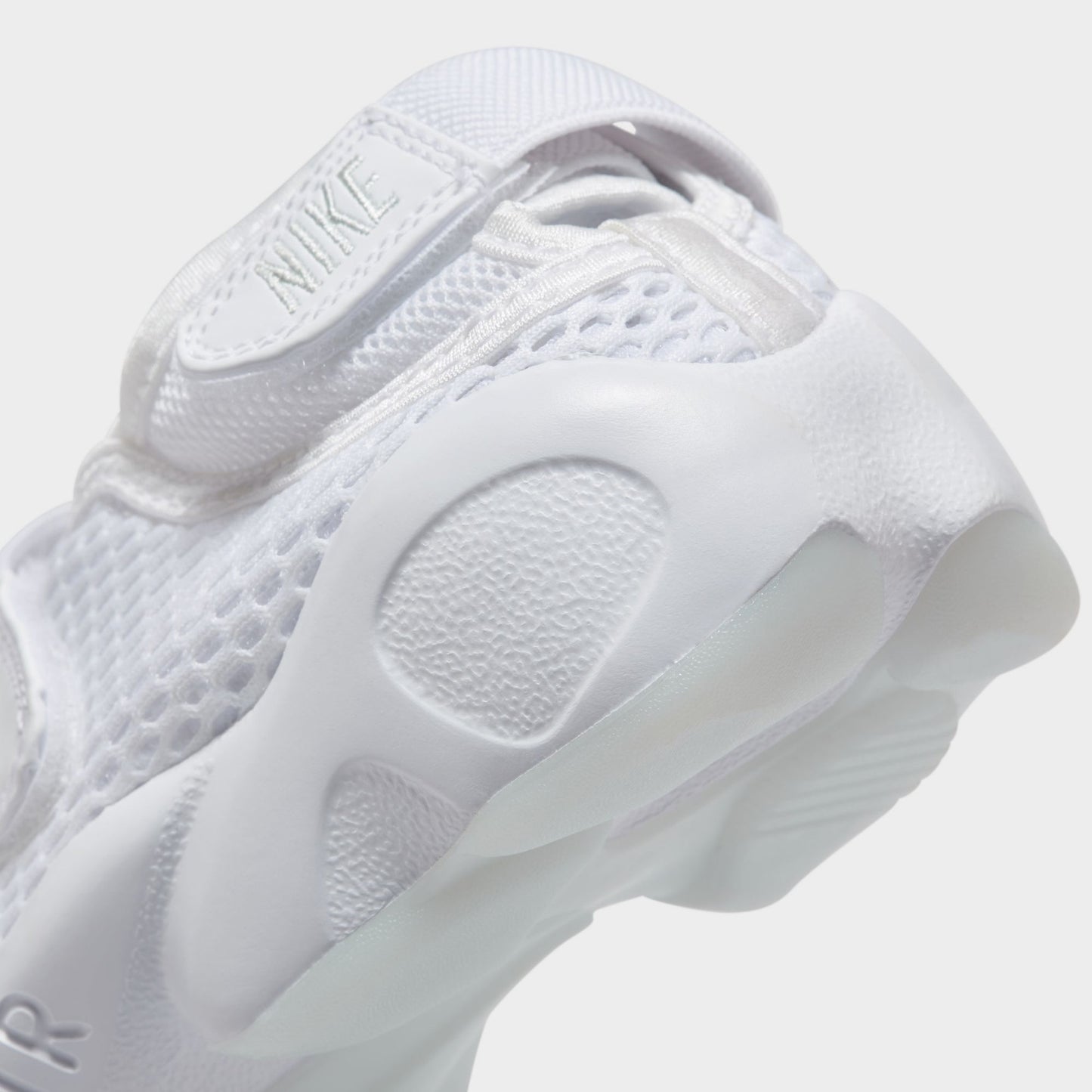Nike Women's Air Rift Breathe. Close-up of white split-toe sneaker showing rounded outsole pods and sculpted heel.