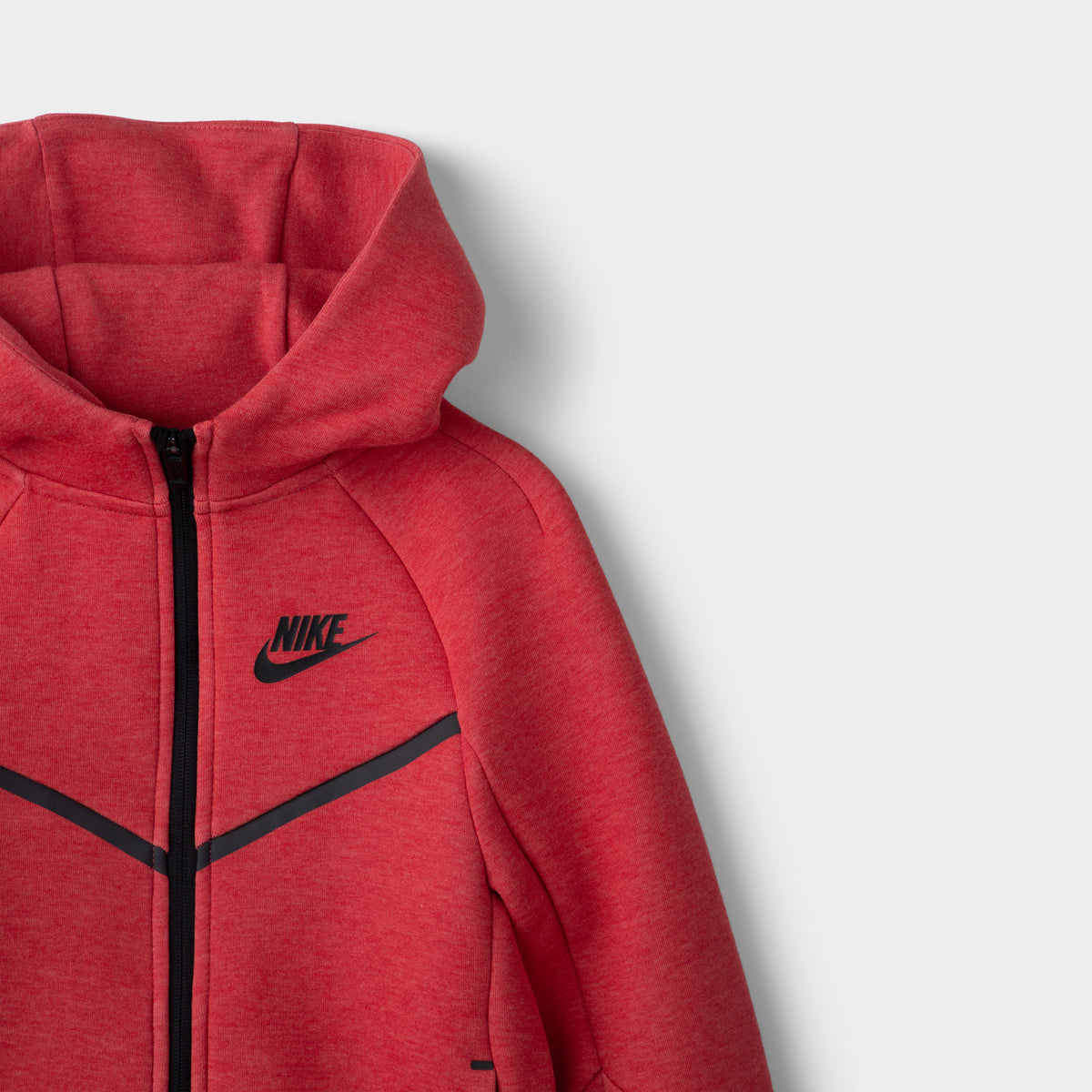 Nike Children's Sportswear Tech Fleece Full Zip Hoodie Set. Close-up of light university red and heather hoodie showing full-zip closure, hood and black Nike chest logo.